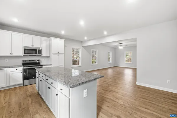 a kitchen with stainless steel appliances granite countertop a sink stove and wooden floor