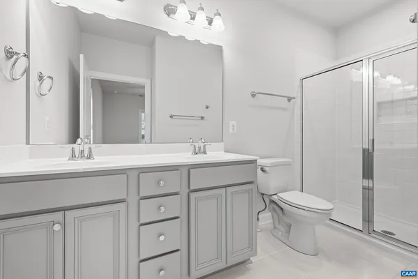 a bathroom with a double vanity sink toilet and a mirror