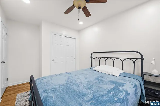 a bedroom with a large bed and ceiling fan
