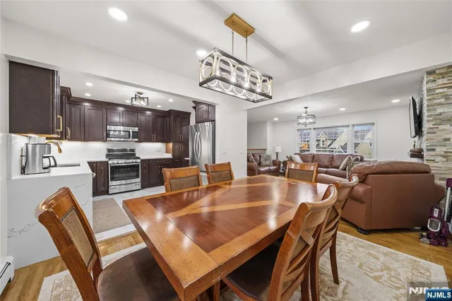 a dining room with kitchen island furniture a chandelier and kitchen view