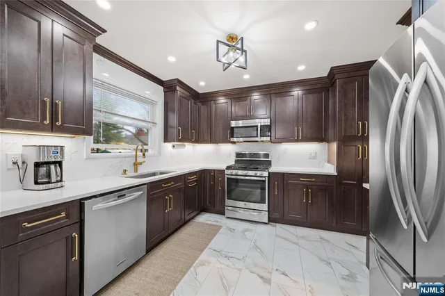 a kitchen with stainless steel appliances granite countertop a refrigerator and a sink