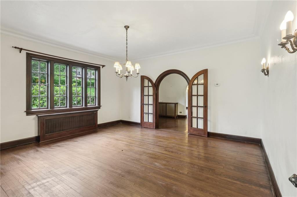 634 West Waldheim Road Pittsburgh, PA 15215 - Photo 11 of 50 a view of an empty room with exposed radiator and wooden floor