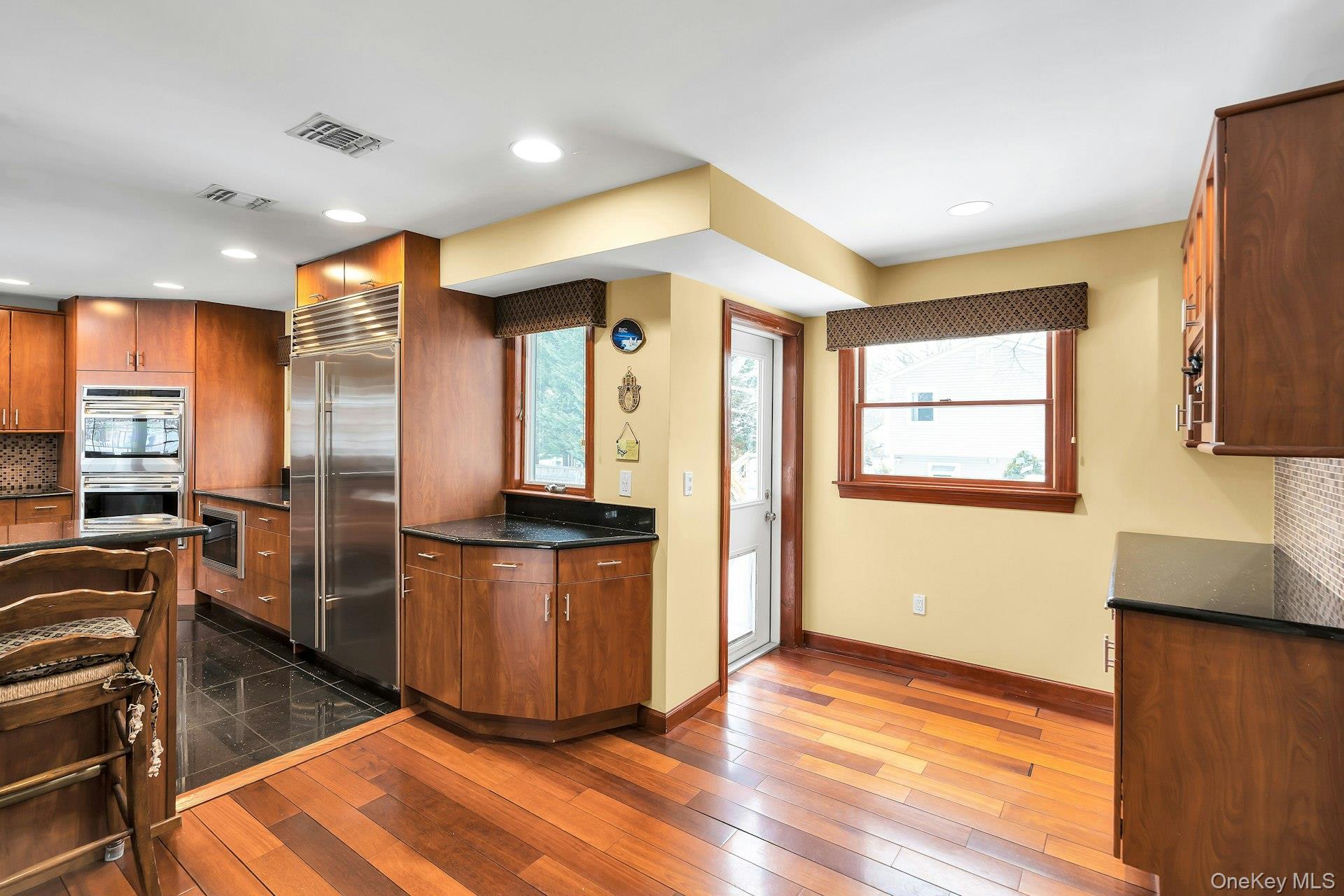 2043 Ripley Lane Merrick, NY 11566 - Photo 19 of 42 a kitchen with stainless steel appliances granite countertop a refrigerator a sink a stove a microwave and wooden floor