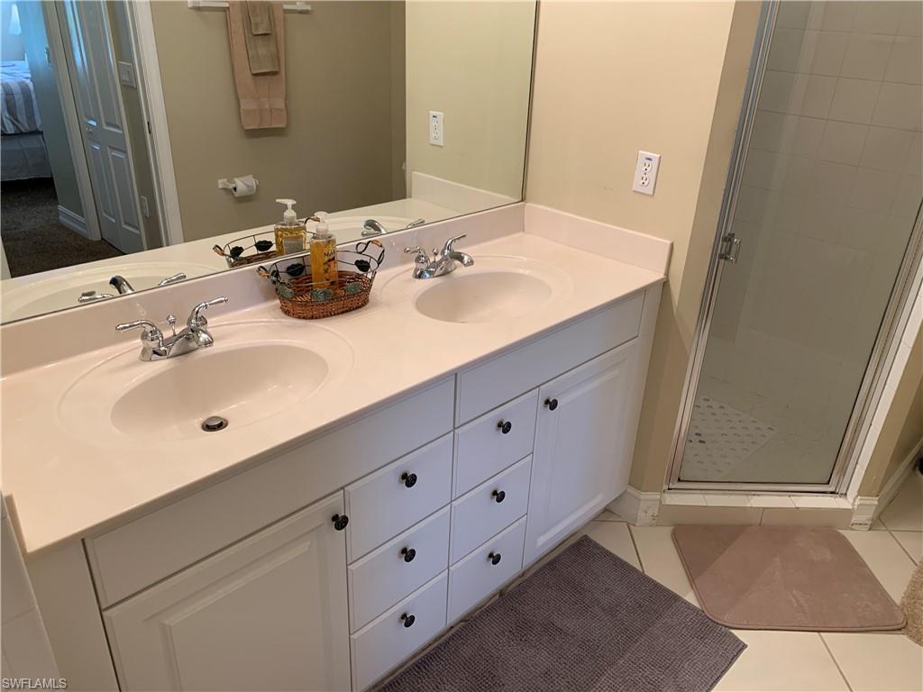 8133 Chancel Court, Unit 641 Naples, FL 34104 - Photo 12 of 25 a bathroom with a double vanity sink and mirror