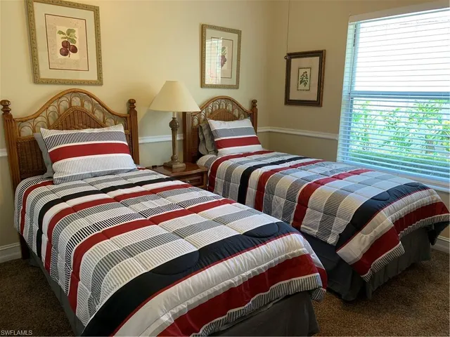 a bedroom with two beds and a window