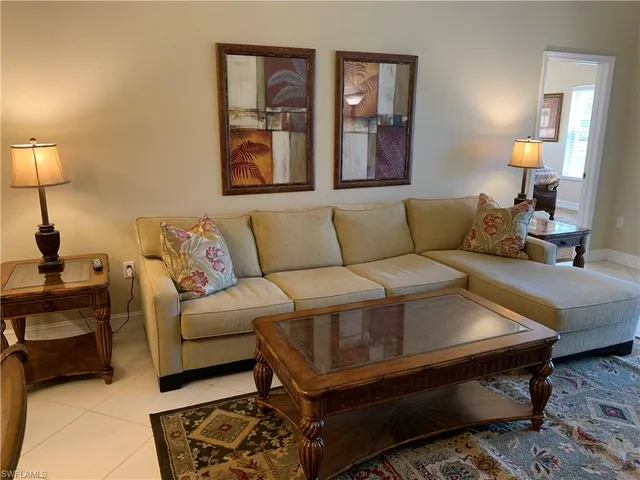 a living room with furniture and a lamp