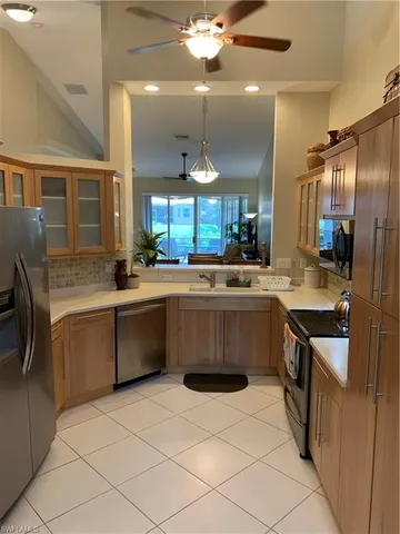 a kitchen with stainless steel appliances a sink counter space cabinets and a large window