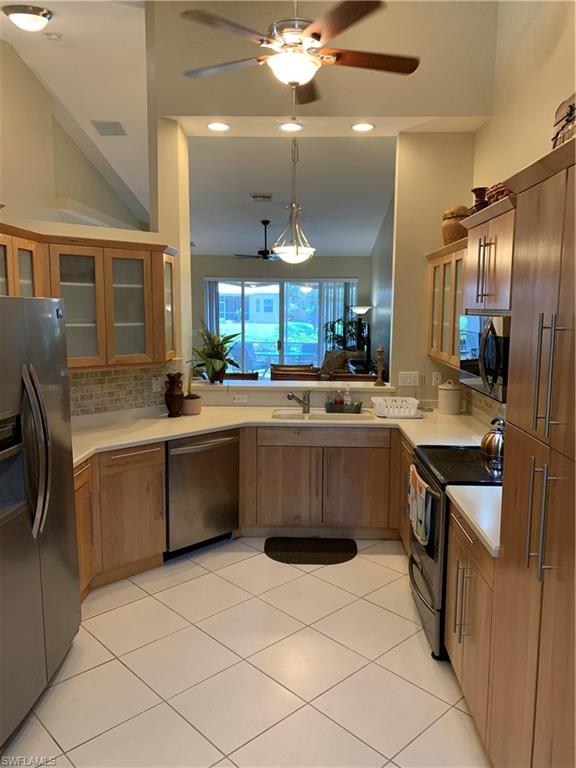 8133 Chancel Court, Unit 641 Naples, FL 34104 - Photo 9 of 25 a kitchen with stainless steel appliances a sink counter space cabinets and a large window