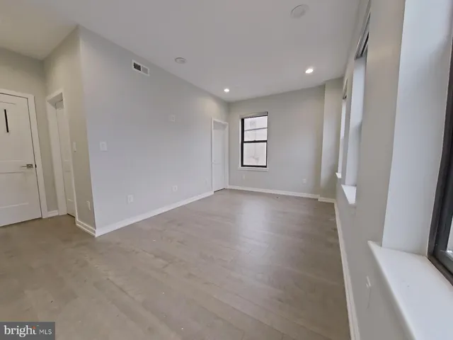 an empty room with windows and closet