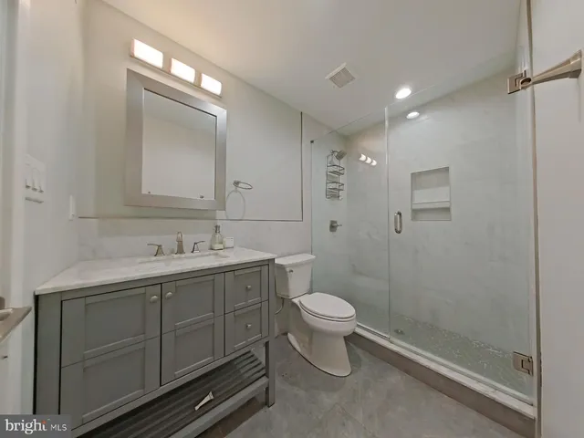 a bathroom with a toilet sink vanity and mirror