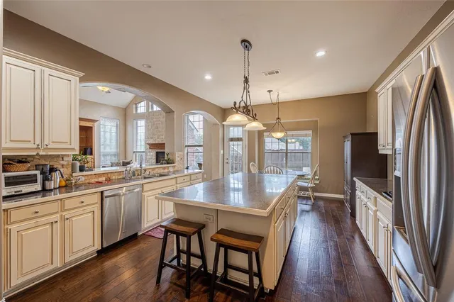 a kitchen with counter space dining table and wooden floor