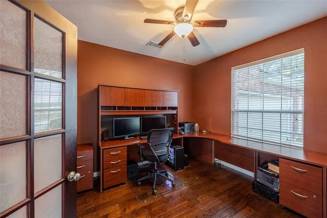 a view of a workspace with furniture and a window