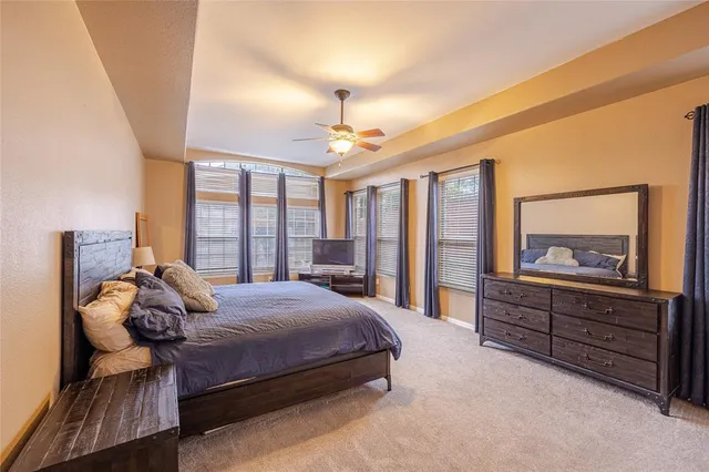 a bedroom with a bed and large windows