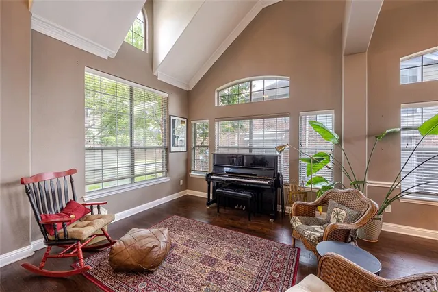 a living room with furniture a rug and a floor to ceiling window