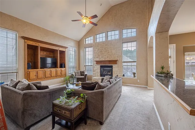 a living room with furniture fireplace and a large window