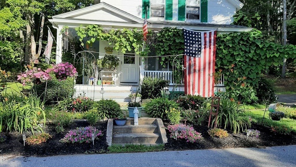 a front view of a house with a porch and a garden