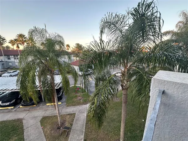 a backyard of a house with table and chairs plants and trees