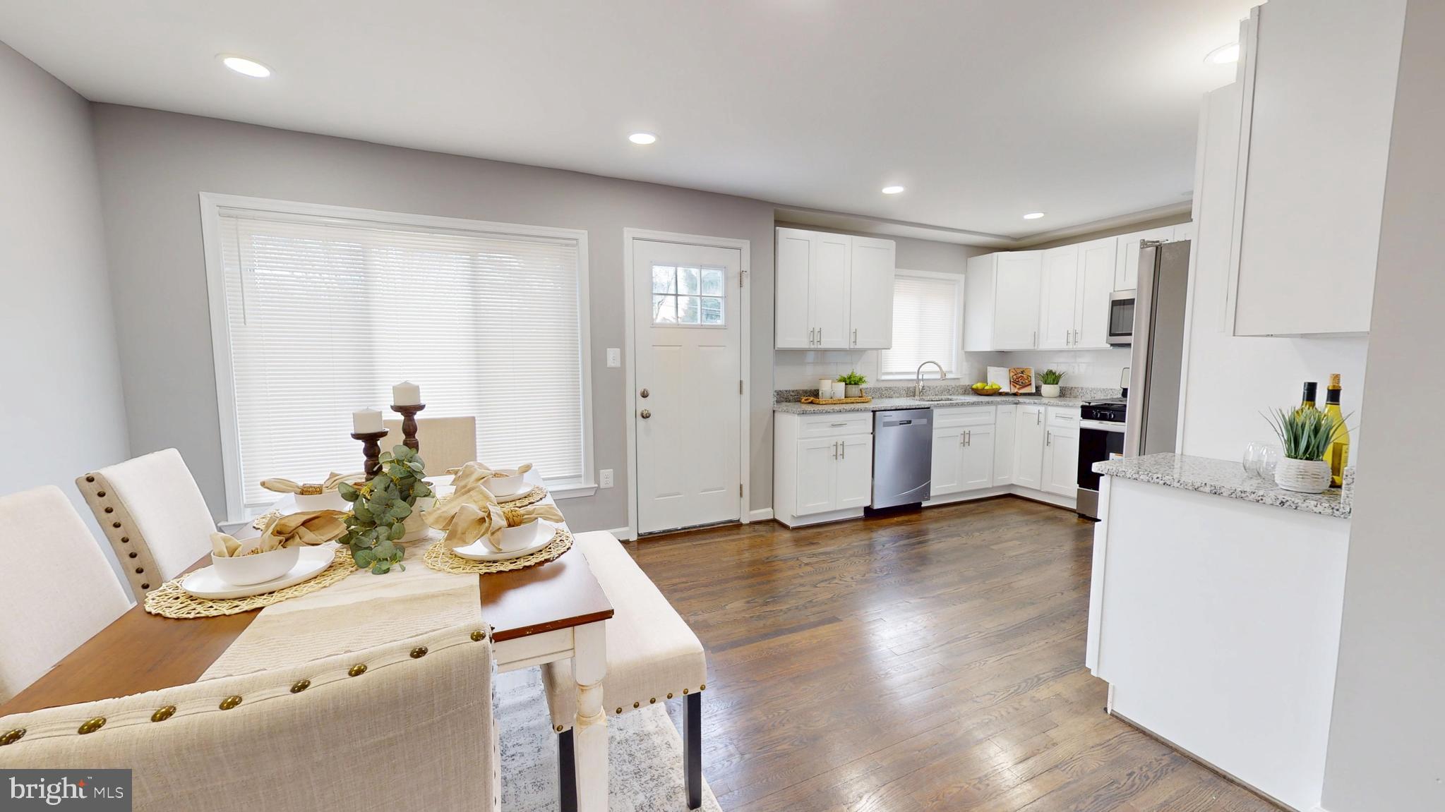 6211 Johnnycake Road Gwynn Oak, MD 21207 - Photo 5 of 26 a kitchen with stainless steel appliances granite countertop a stove and white cabinets with wooden floor