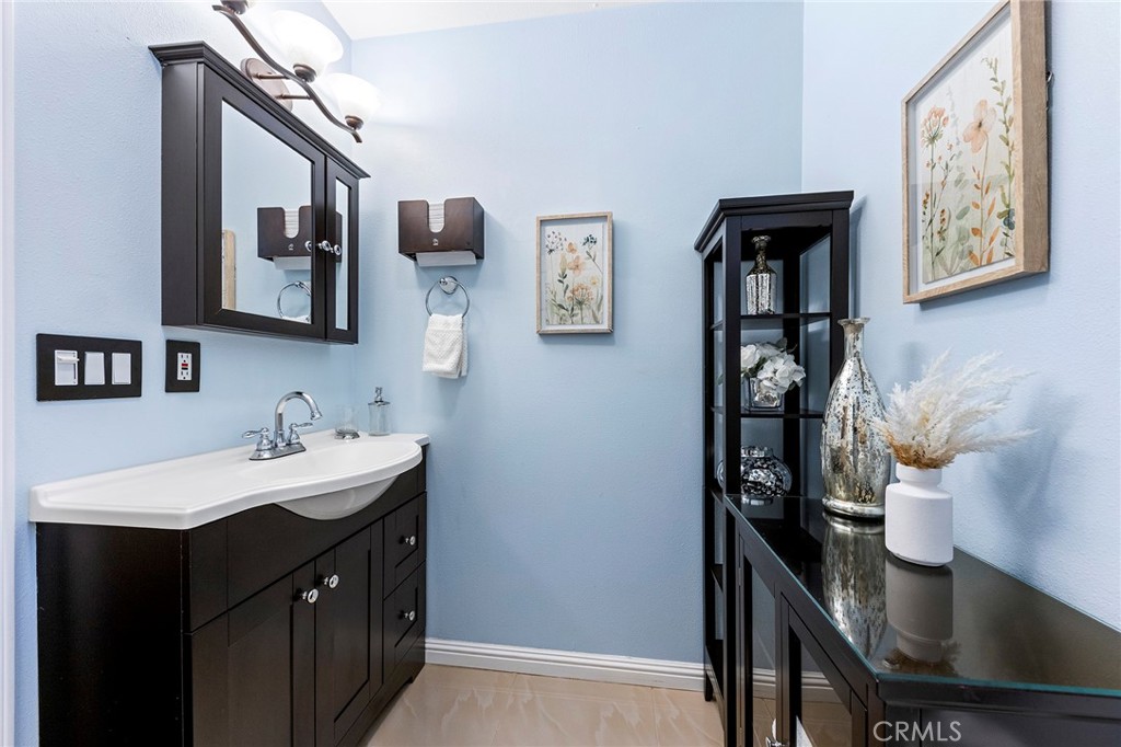 1608 Cedar Avenue Long Beach, CA 90813 - Photo 23 of 45 a bathroom with a sink a mirror and painting on the wall