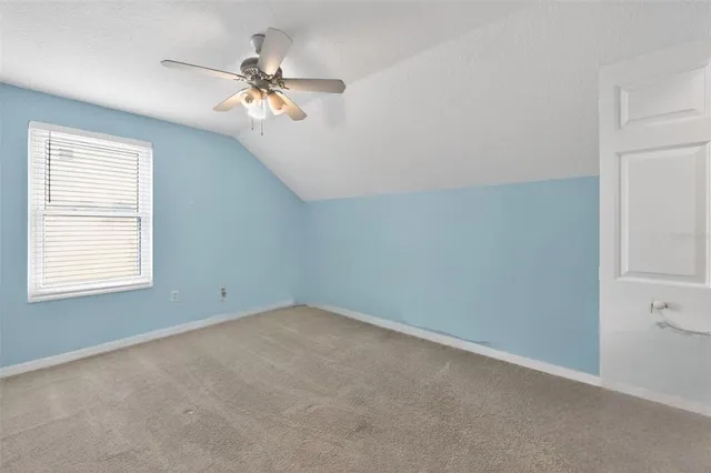 an empty room with a ceiling fan and a window