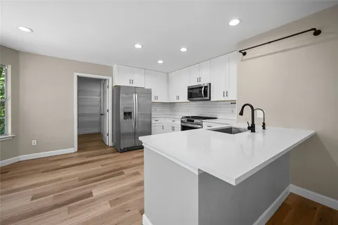 a kitchen with stainless steel appliances a sink stove and refrigerator