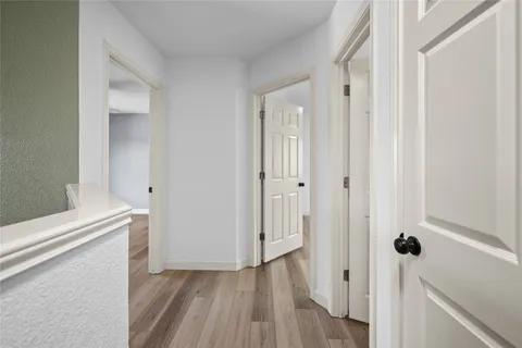 a view of a hallway with wooden floor and staircase