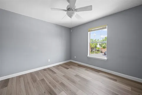 an empty room with a window and a ceiling fan