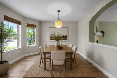a dining room with furniture a chandelier and wooden floor