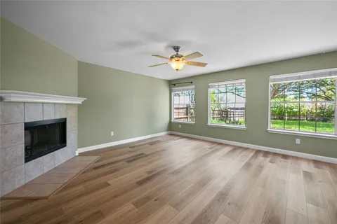 a view of an empty room with a window and fireplace