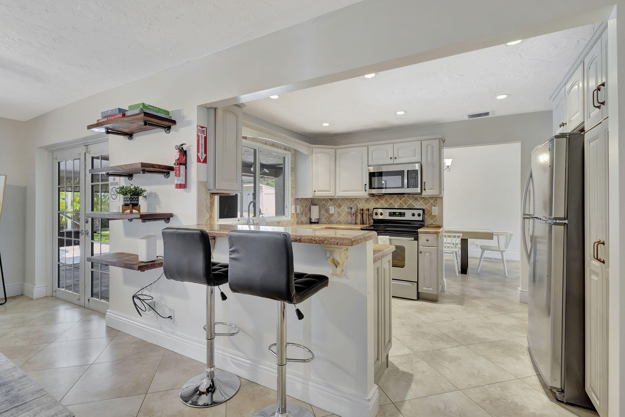 1104 Jackpine Street Wellington, FL 33414 - Photo 19 of 67 a kitchen with stainless steel appliances kitchen island granite countertop a refrigerator and cabinets