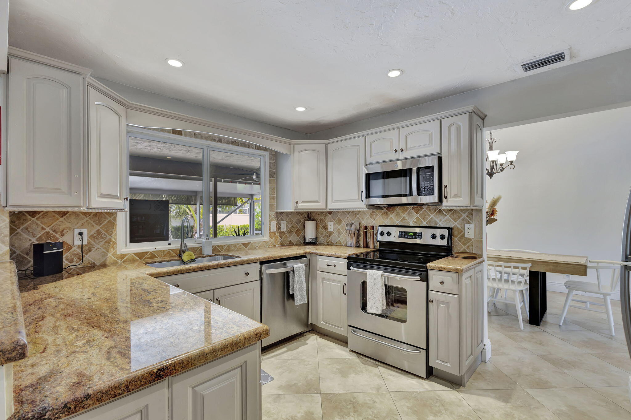 1104 Jackpine Street Wellington, FL 33414 - Photo 22 of 67 a kitchen with stainless steel appliances granite countertop a stove a sink and a microwave