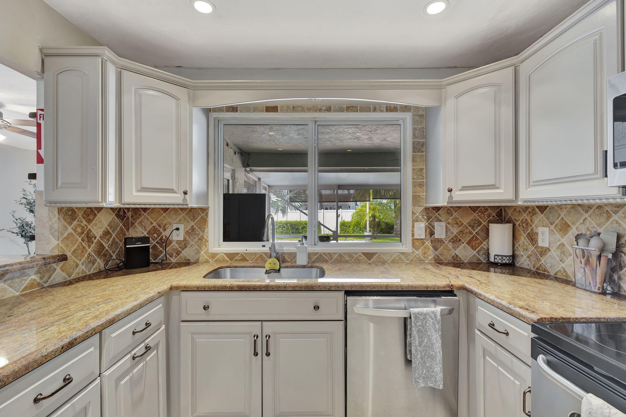 1104 Jackpine Street Wellington, FL 33414 - Photo 23 of 67 a kitchen with stainless steel appliances granite countertop white cabinets and a window