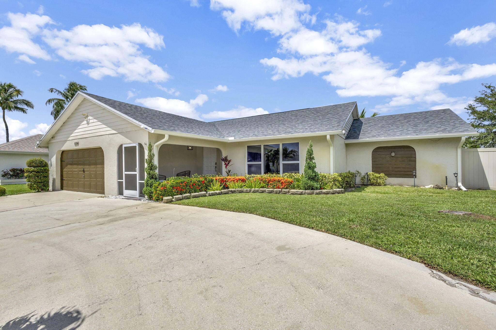 1104 Jackpine Street Wellington, FL 33414 - Photo 30 of 67 a front view of a house with a yard and garage