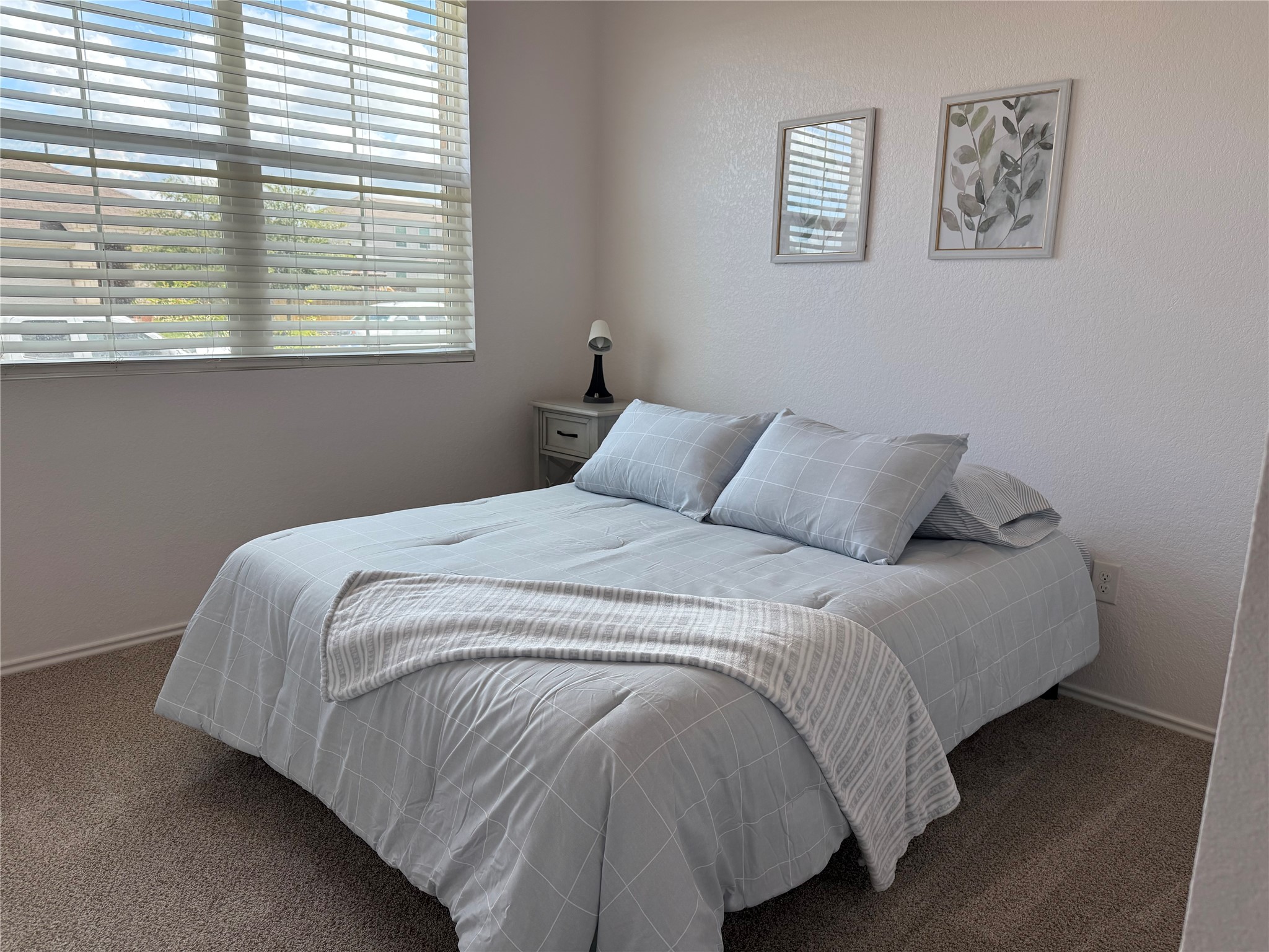 14907 Retha Pass Austin, TX 78725 - Photo 7 of 22 A comfortable bedroom features soft carpeting and a window with natural light.