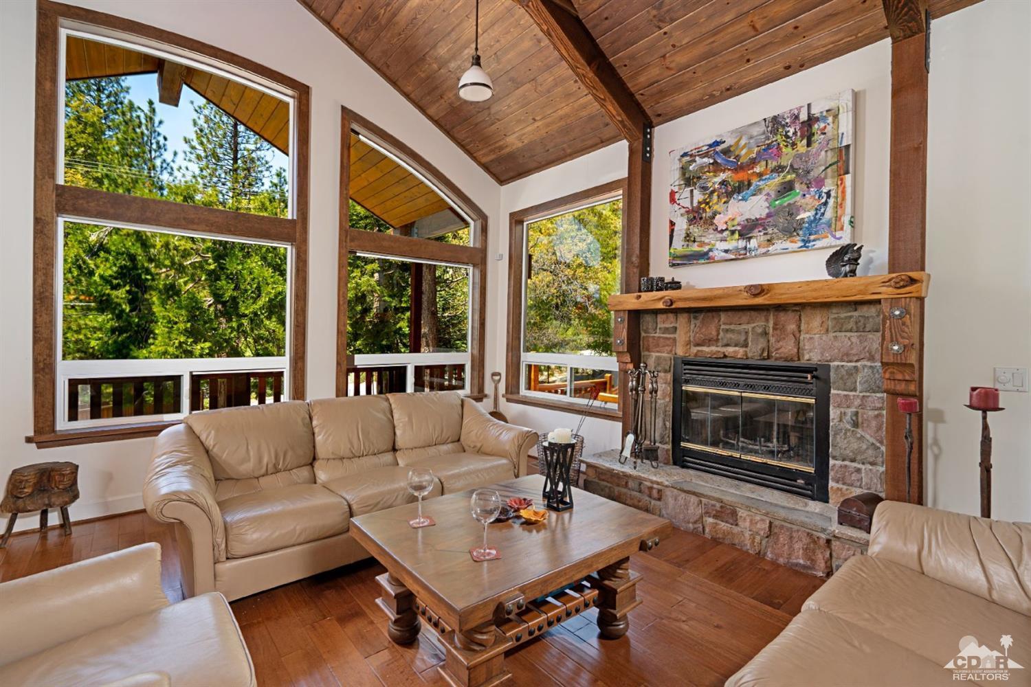 24838 Fern Valley Road Idyllwild, CA 92549 - Photo 2 of 38 a living room with furniture a fireplace and a large window