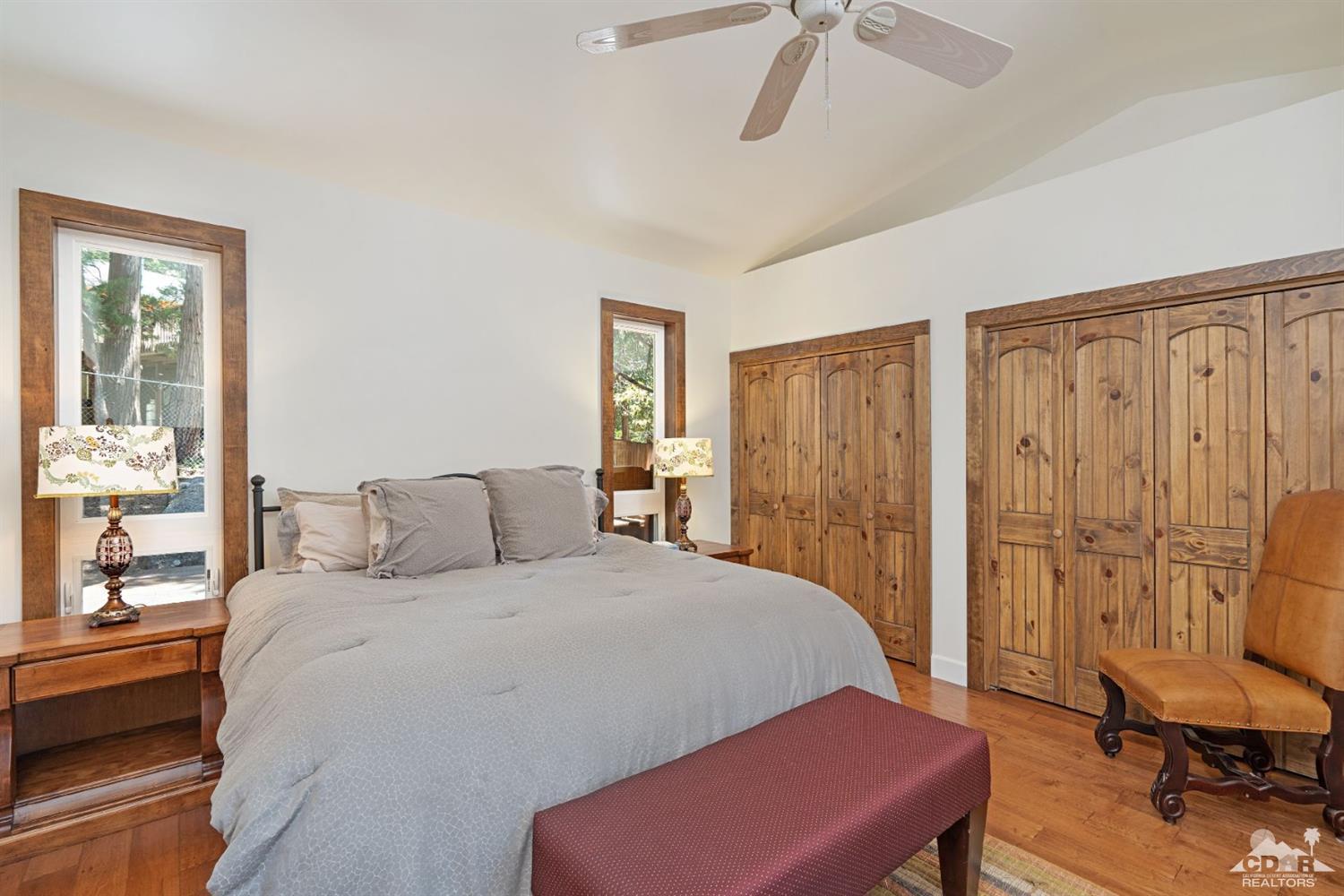 24838 Fern Valley Road Idyllwild, CA 92549 - Photo 16 of 38 a bedroom with a bed and a chandelier