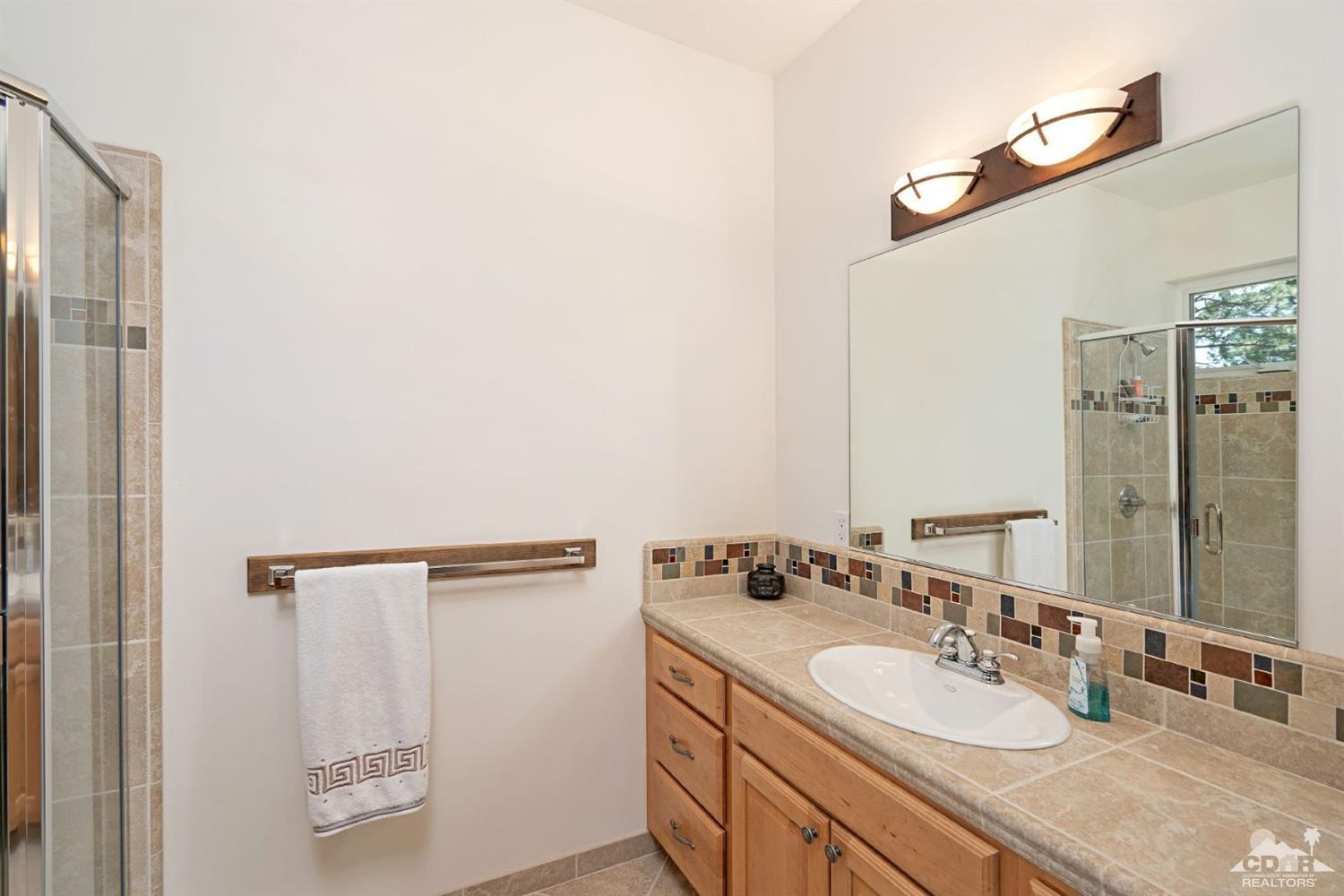 24838 Fern Valley Road Idyllwild, CA 92549 - Photo 19 of 38 a bathroom with a double vanity sink and a mirror