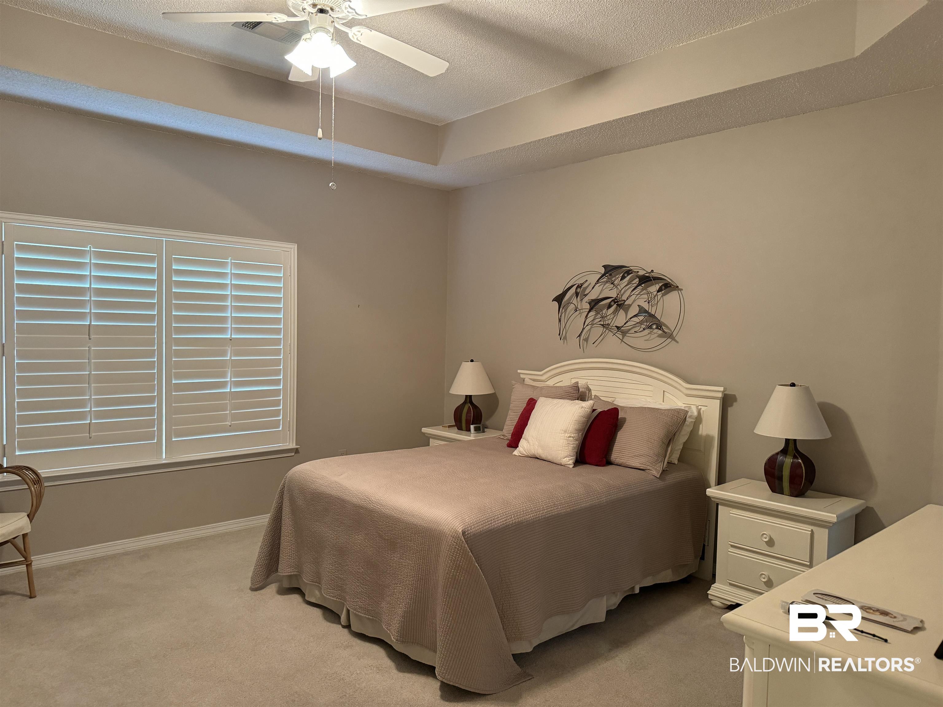 9139 Clubhouse Drive Foley, AL 36535 - Photo 19 of 30 Carpeted bedroom featuring a raised ceiling, a textured ceiling, and ceiling fan
