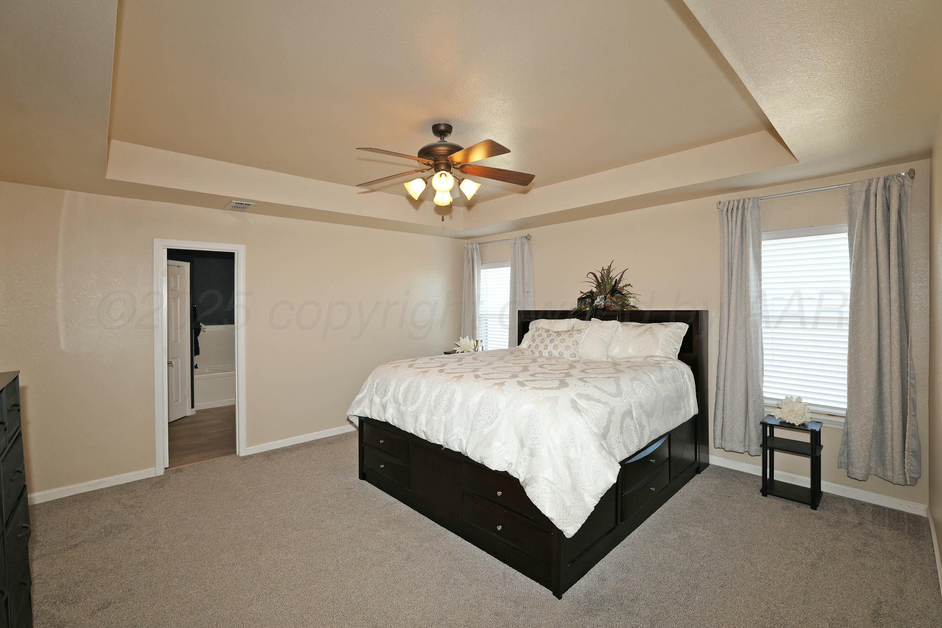 800 West McAfee Road Amarillo, TX 79118 - Photo 13 of 39 a spacious bedroom with a bed and a chandelier
