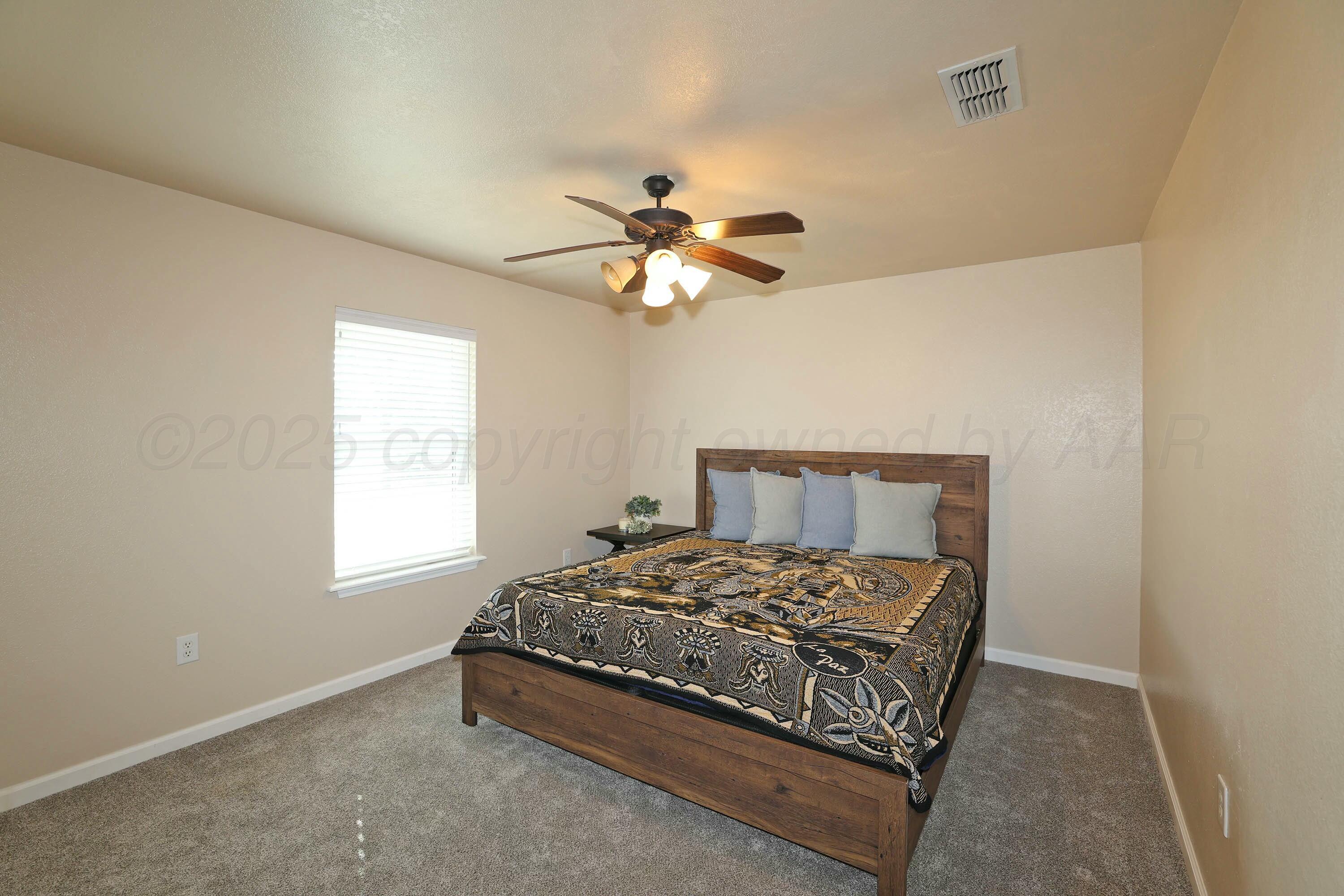 800 West McAfee Road Amarillo, TX 79118 - Photo 18 of 39 a bedroom with a bed and a chandelier