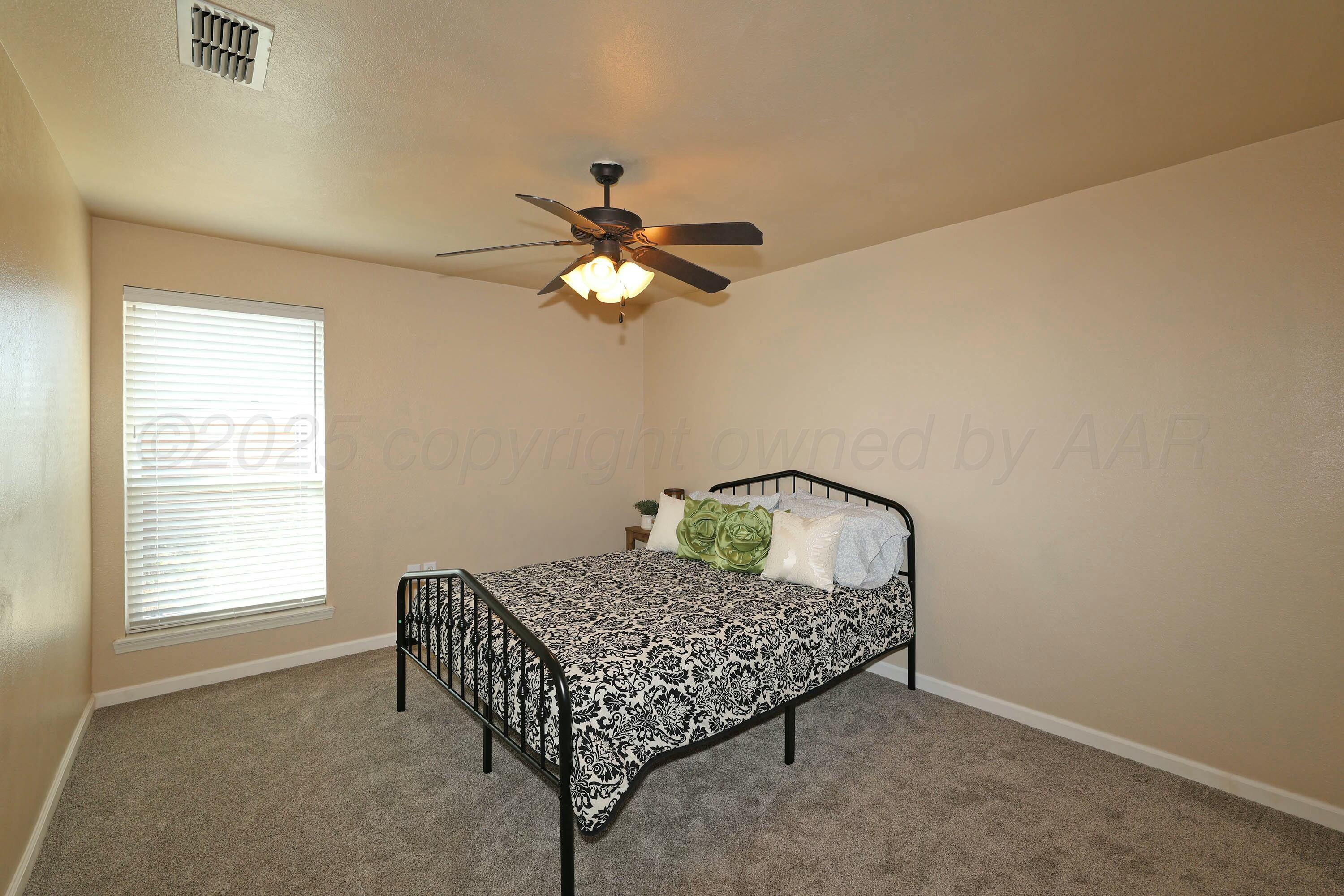 800 West McAfee Road Amarillo, TX 79118 - Photo 20 of 39 a bedroom with a bed window and a chandelier