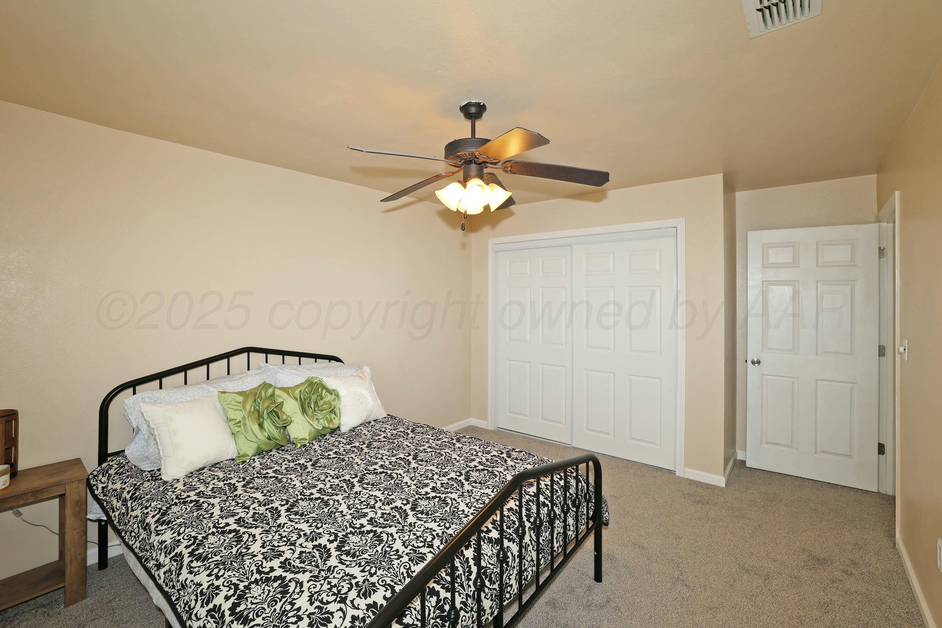 800 West McAfee Road Amarillo, TX 79118 - Photo 22 of 39 a bedroom with a bed and a chandelier
