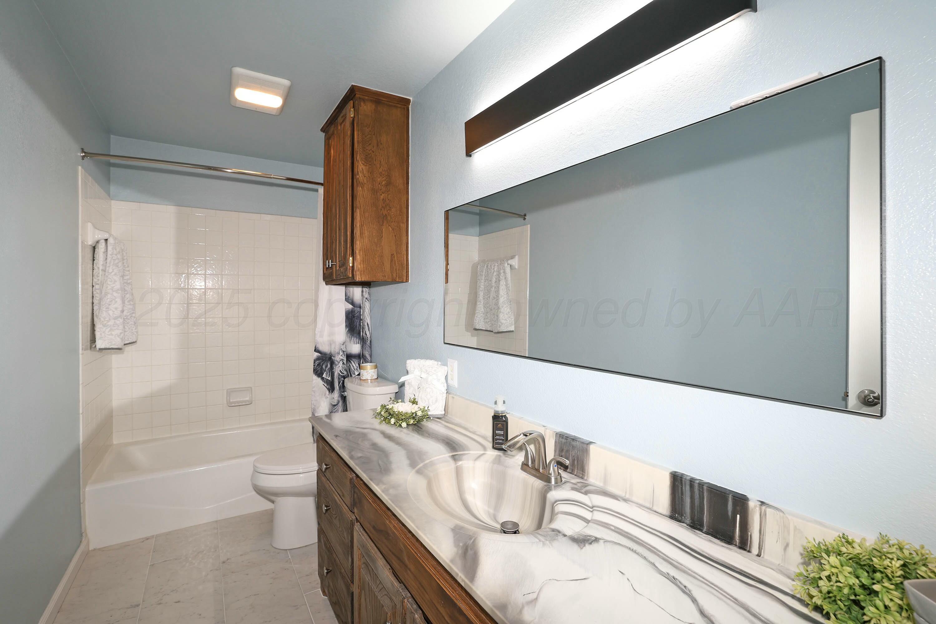 800 West McAfee Road Amarillo, TX 79118 - Photo 23 of 39 a bathroom with a granite countertop sink a toilet and shower