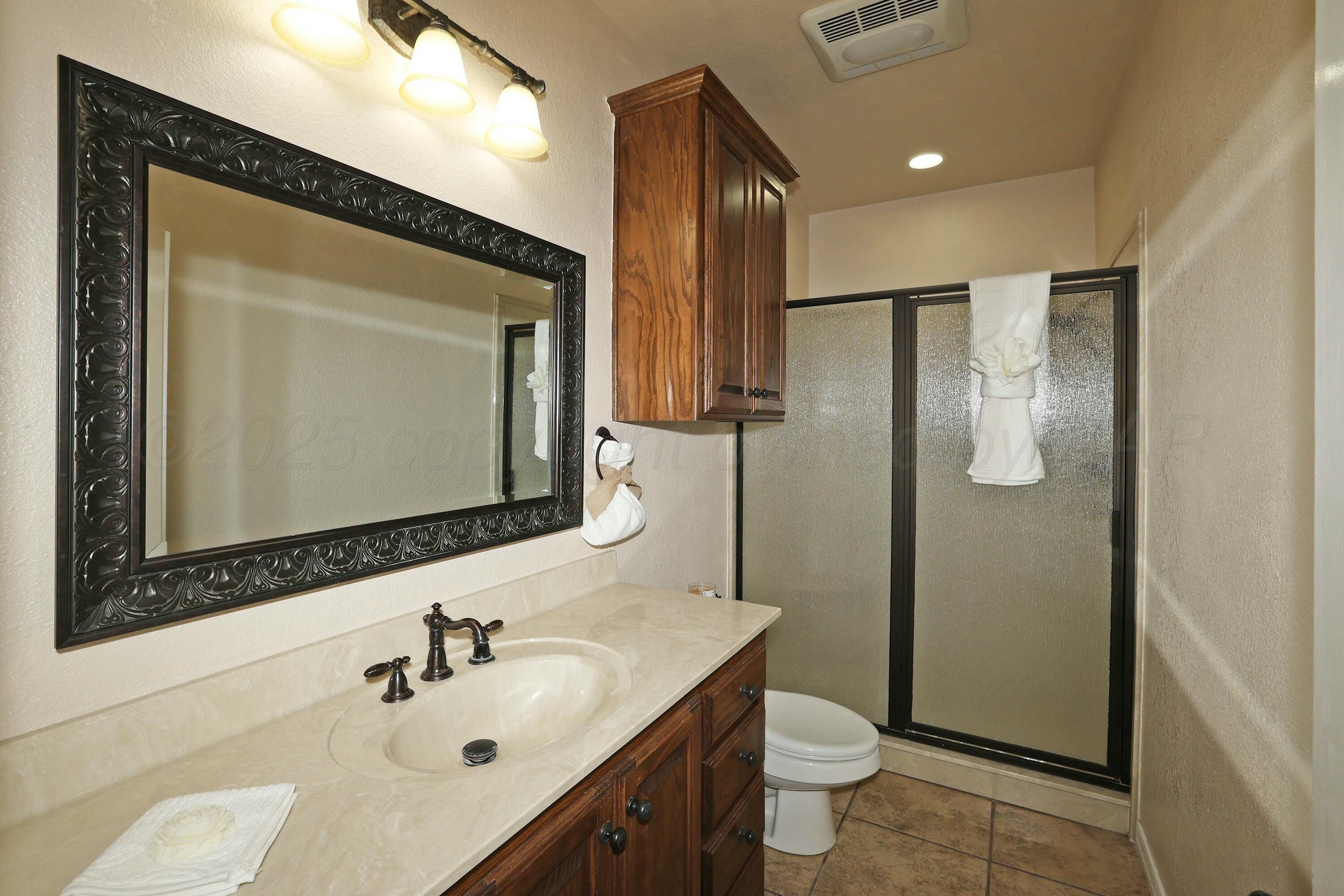 800 West McAfee Road Amarillo, TX 79118 - Photo 29 of 39 a bathroom with a toilet sink shower and mirror