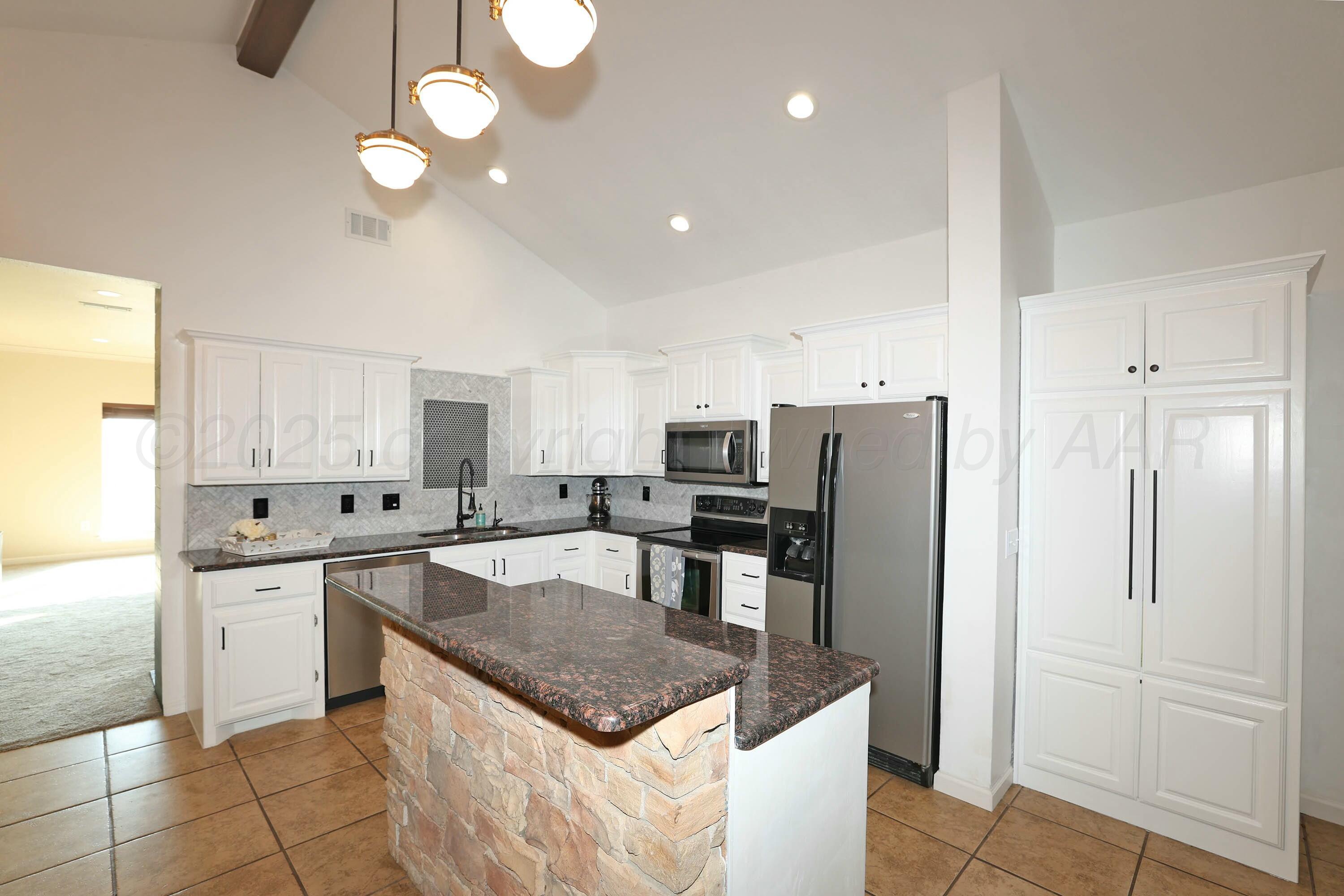 800 West McAfee Road Amarillo, TX 79118 - Photo 8 of 39 a kitchen with stainless steel appliances granite countertop a sink a stove a refrigerator and island