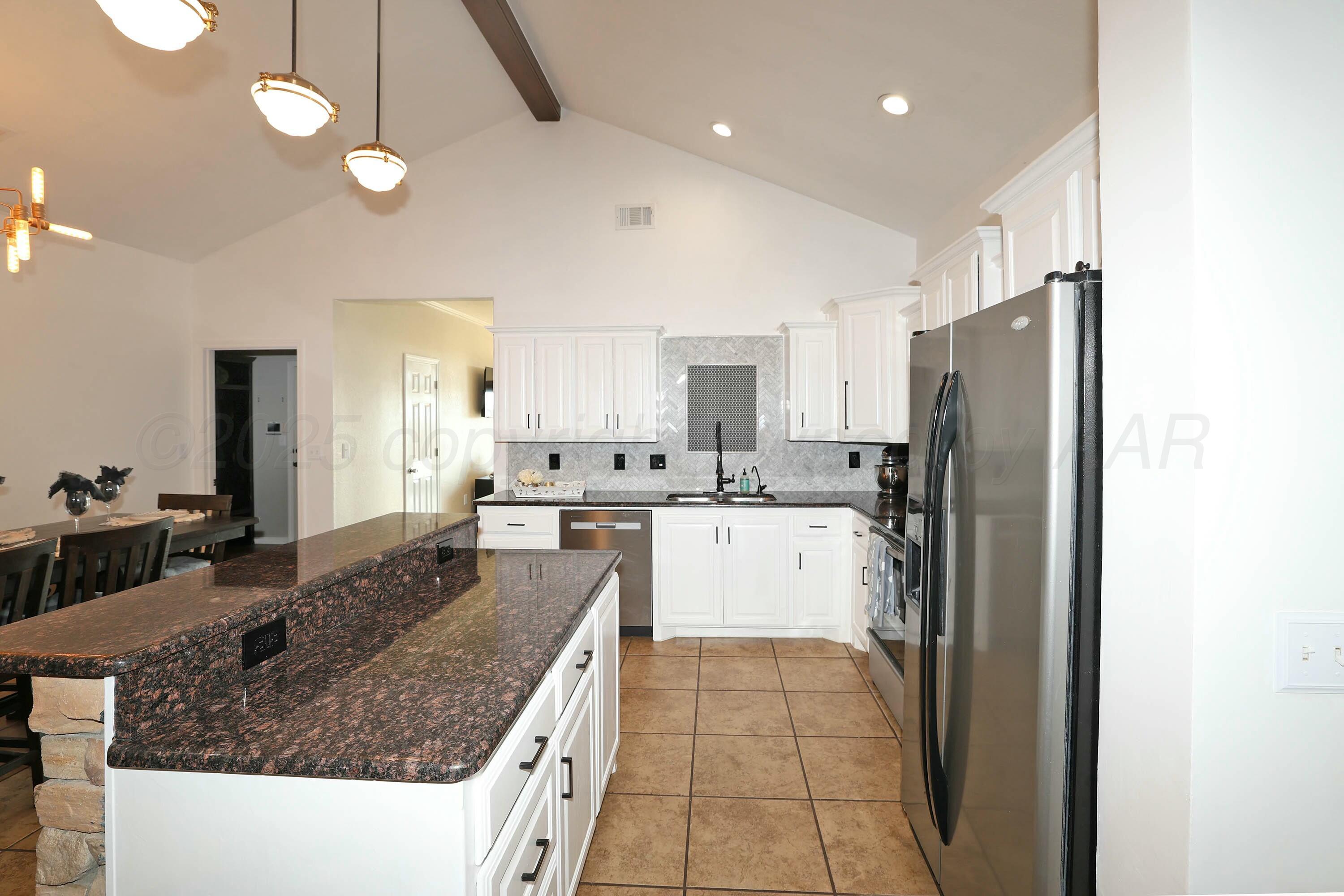 800 West McAfee Road Amarillo, TX 79118 - Photo 9 of 39 a kitchen with stainless steel appliances granite countertop a refrigerator a sink and white cabinets