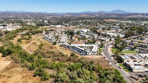 an aerial view of residential house with parking and mountain view in back