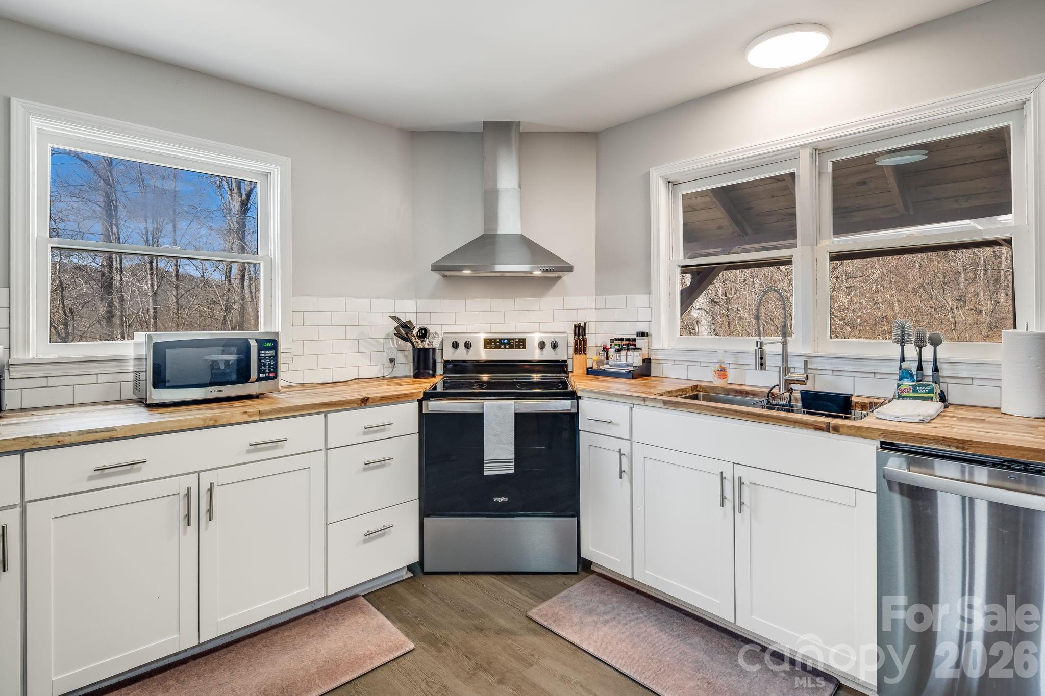 114 Johns Creek Road Canton, NC 28716 - Photo 14 of 48 a kitchen with stainless steel appliances granite countertop a stove a sink and a granite counter tops with a large window