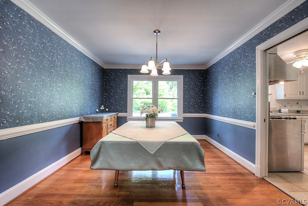 7720 Varann Road Henrico, VA 23231 - Photo 21 of 39 a large white kitchen with wooden floor and a chandelier