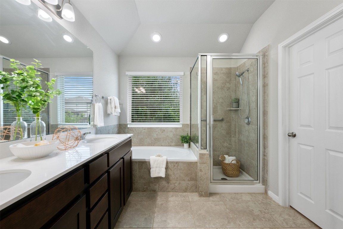 433 Rusk Bluff Avenue Leander, TX 78641 - Photo 11 of 22 Full bathroom featuring a garden tub, double vanity, a shower stall, recessed lighting, and vaulted ceiling